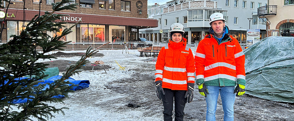 Rebecca Lennéer och Mattias Modén från PEAB. De står på Stora torget med en julgran i förgrunden och butiker i bakgrunden.